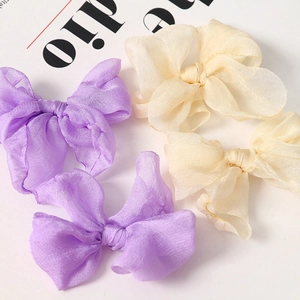 Dettaglio macro di fiocchi in organza viola e beige per accessori capelli e fai-da-te