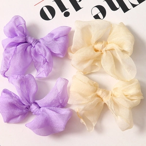 Fiocchi per capelli in organza viola e beige con una consistenza morbida e traslucida