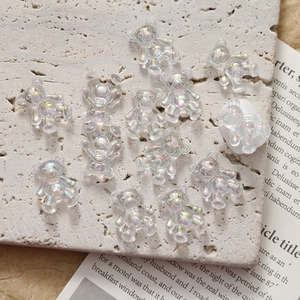 Macro detail of transparent iridescent 3D bear resin charms for DIY nail art and crafts