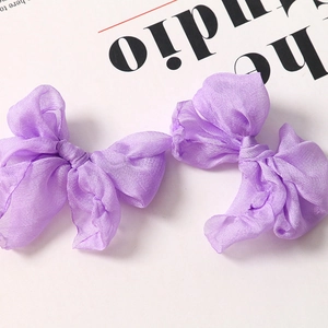 Dettaglio di eleganti fiocchi in organza viola con finitura traslucida per accessori per capelli