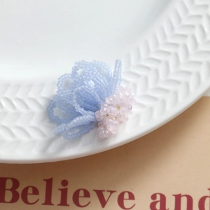 Detailed view of handmade blue seed bead flower with pink multifaceted bead center