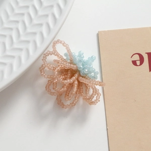 Macro shot of handmade woven flower bead accessory in pink and blue for DIY jewelry