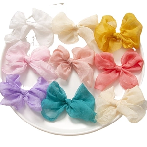 Set di 9 fermagli per capelli con fiocco in organza colorata su un vassoio bianco