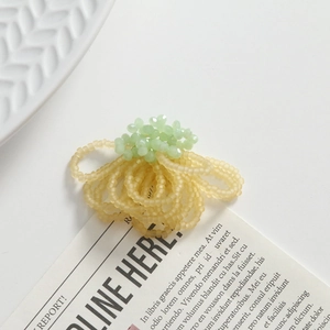 Detailed view of handmade beaded flower jewelry with frosted beige and green crystal beads