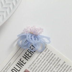 Close-up of handmade pink crystal and blue seed bead floral jewelry accessories