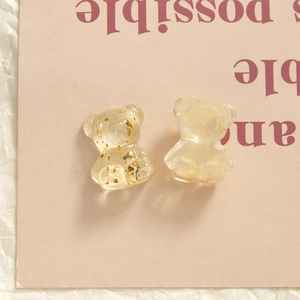 Macro shot of two bear-shaped resin DIY charms with transparent yellow gold foil