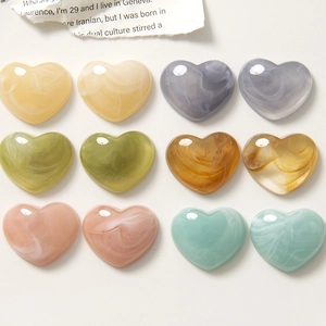 Detail view of heart-shaped resin charms with marble texture for DIY jewelry making