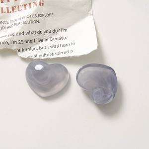 Macro shot of smoky grey heart resin pendants with white marble texture for DIY jewelry
