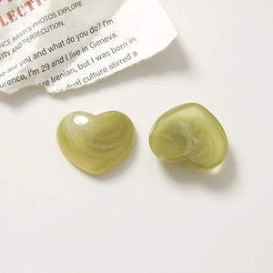 Detail of green resin heart charms with ink-wash marble texture for DIY jewelry making