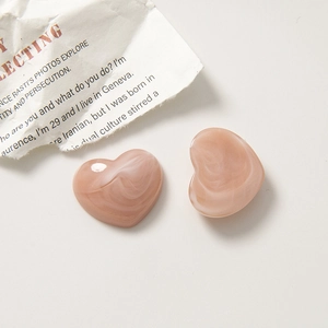 Close-up of pink ink-wash marble texture resin heart-shaped jewelry accessories