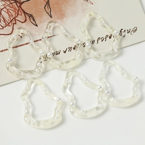 Detalle de dijes de resina con perlas para joyería DIY y accesorios elegantes para el pelo