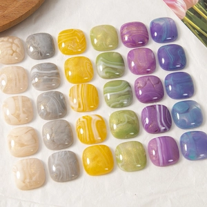 Detail van vierkante hars cabochons met marmeren textuur en goudfolie voor DIY-sieraden