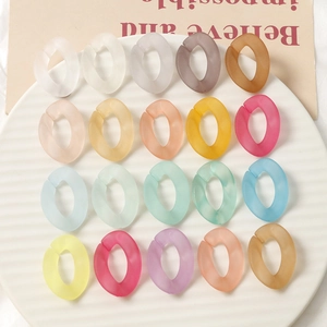 Détail de maillons en acrylique mat translucide aux couleurs macaron sur un plateau