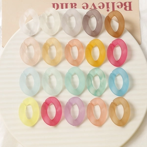 Vue à plat de vingt maillons colorés en acrylique mat sur une assiette en porcelaine rayée