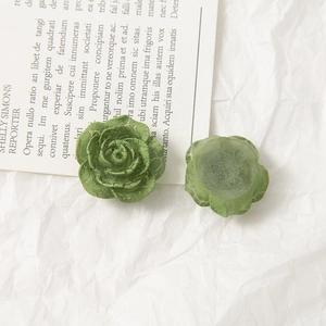 Detailed macro view of vintage moss green acrylic roses with antique crackle texture