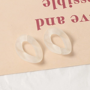 Détail de maillons torsadés en acrylique givré blanc cassé pour création de bijoux