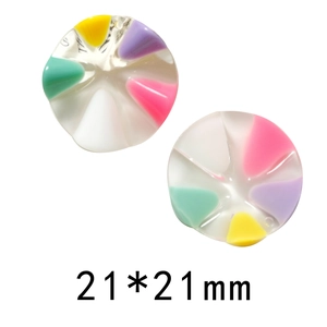 Dettaglio macro di ciondoli tondi in resina da 21mm con motivi a spicchi multicolore
