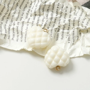 Detalle macro de colgantes de corazón acolchados blanco crema con anillos de oro retro