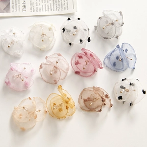 Detailed flat lay of colorful chiffon petal jewelry charms with gold center beads