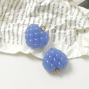 Detalle de dijes de corazón morados acolchados con aros dorados para joyería artesanal