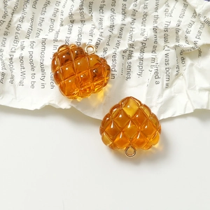 Detalle macro de colgantes de corazón de resina ámbar con textura acolchada y aros dorados