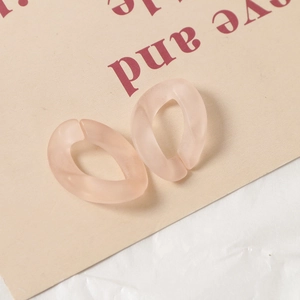 Gros plan de boucles ovales en acrylique rose clair mat translucide pour accessoires DIY