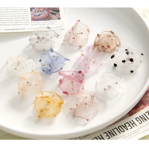 Close-up of assorted sheer organza fabric flower charms with beaded gold pistils