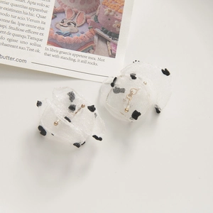 Detailed view of white polka dot organza fabric earrings with gold metal studs