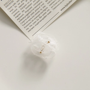 Detail of delicate white mesh fabric flower with golden bead center for DIY jewelry