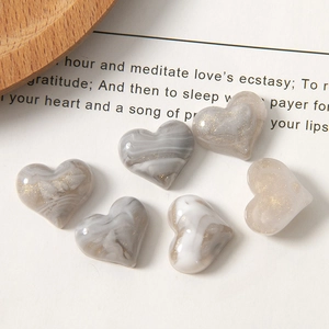 Detail of marble pattern resin heart charms with gold flakes for DIY jewelry making
