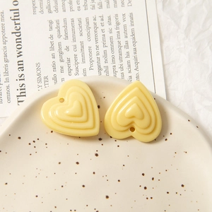 Vue macro de breloques en acrylique jaune en forme de cœur pour bijoux DIY