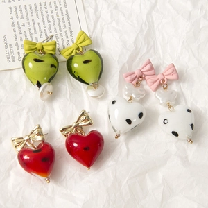 Dettagli di ciondoli in vetro a cuore con pois dipinti e piccoli fiocchi colorati