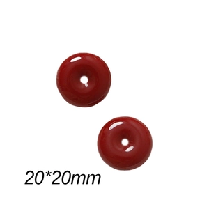 Close-up of two red 20mm round resin charms with a smooth jade-like finish for DIY jewelry