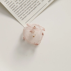 Macro detail of a soft pink organza woven petal handmade hair clip or earring accessory