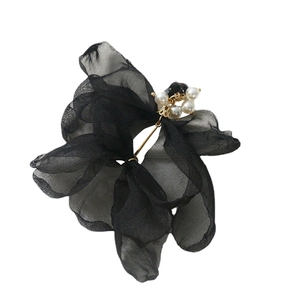 Détail d'un accessoire cheveux fleur en organza noir avec perles blanches et gemme