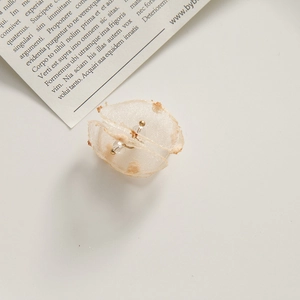 Detailed close-up of light champagne organza petal earrings with gold beads and mesh layers