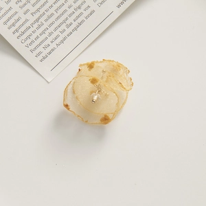 Detailed macro view of delicate golden mesh flower petals with pearl center for DIY crafts
