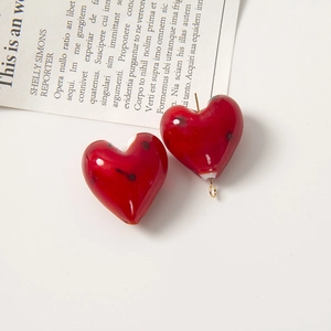 Dettaglio macro di perle in vetro rosso a forma di cuore con pois per creazione di gioielli