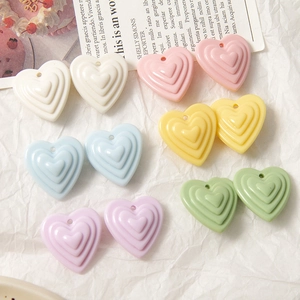 Détail macro de pendentifs cœur multicouches aux couleurs pastel pour la création de bijoux