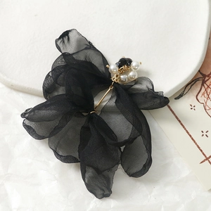 Détail d'un nœud papillon en organza noir avec perles élégantes et touches métalliques dorées