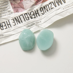 Détails macro de deux breloques en résine vert clair marbrée pour bijoux DIY