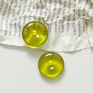 Macro shot of grass green translucent 20mm round resin charms with polished surface