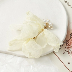 Détail macro d'une fleur élégante en organza jaune avec perles et base en métal doré
