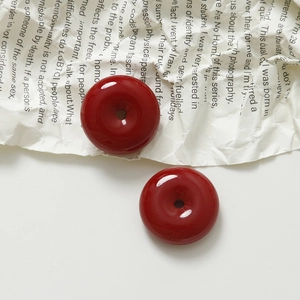Macro view of two polished red resin ring pendants for DIY earring jewelry making