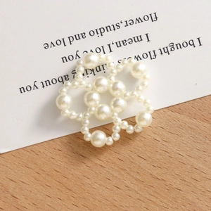 Détail d'un accessoire floral en perles baroques tissées main sur bois rustique