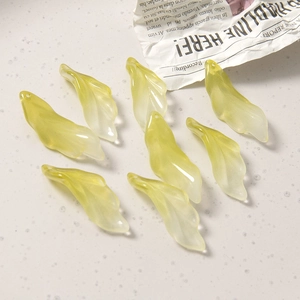 Detail van半transparante gele glazen kralen in bladvorm voor het maken van DIY-sieraden