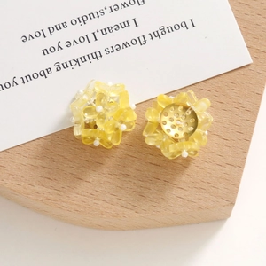 Detailansicht der gelben Harz-Ohrringe in Blumenform mit goldenem Metall-Untersatz