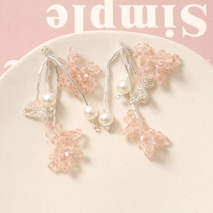 Pink crystal flower tassel earrings with pearls on a minimalist decorative tray