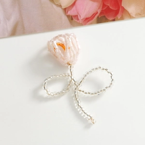 Detailed close-up of handmade pink beaded tulip flower charm for DIY jewelry and crafts