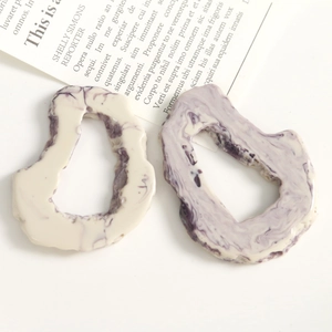 Detalle de dijes de resina marmoleada púrpura para aretes y accesorios de joyería DIY